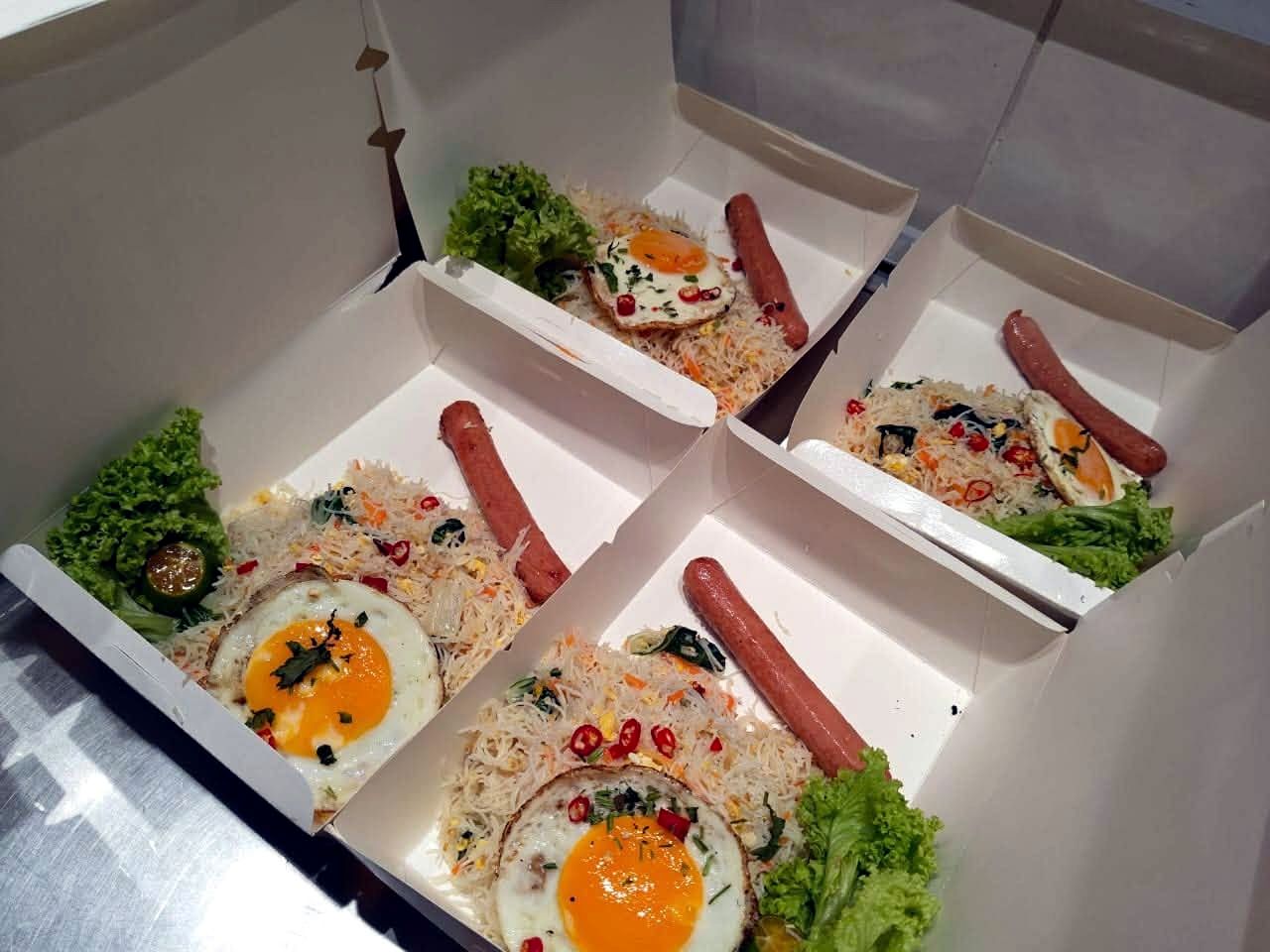 Packed breakfast boxes with sausage, egg and fried rice