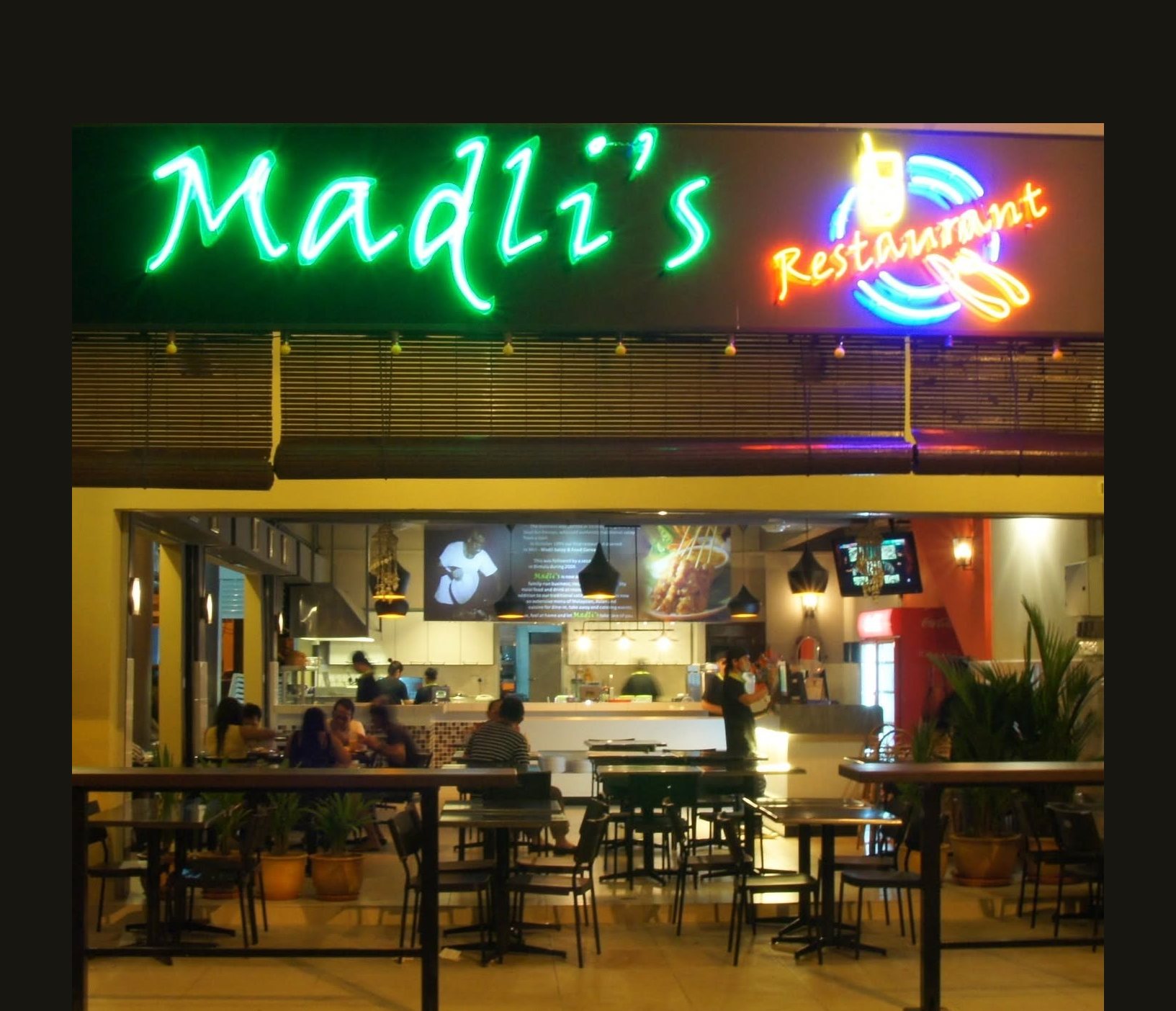 Madli's restaurant at night, the neon sign glowing above the busy open dining front