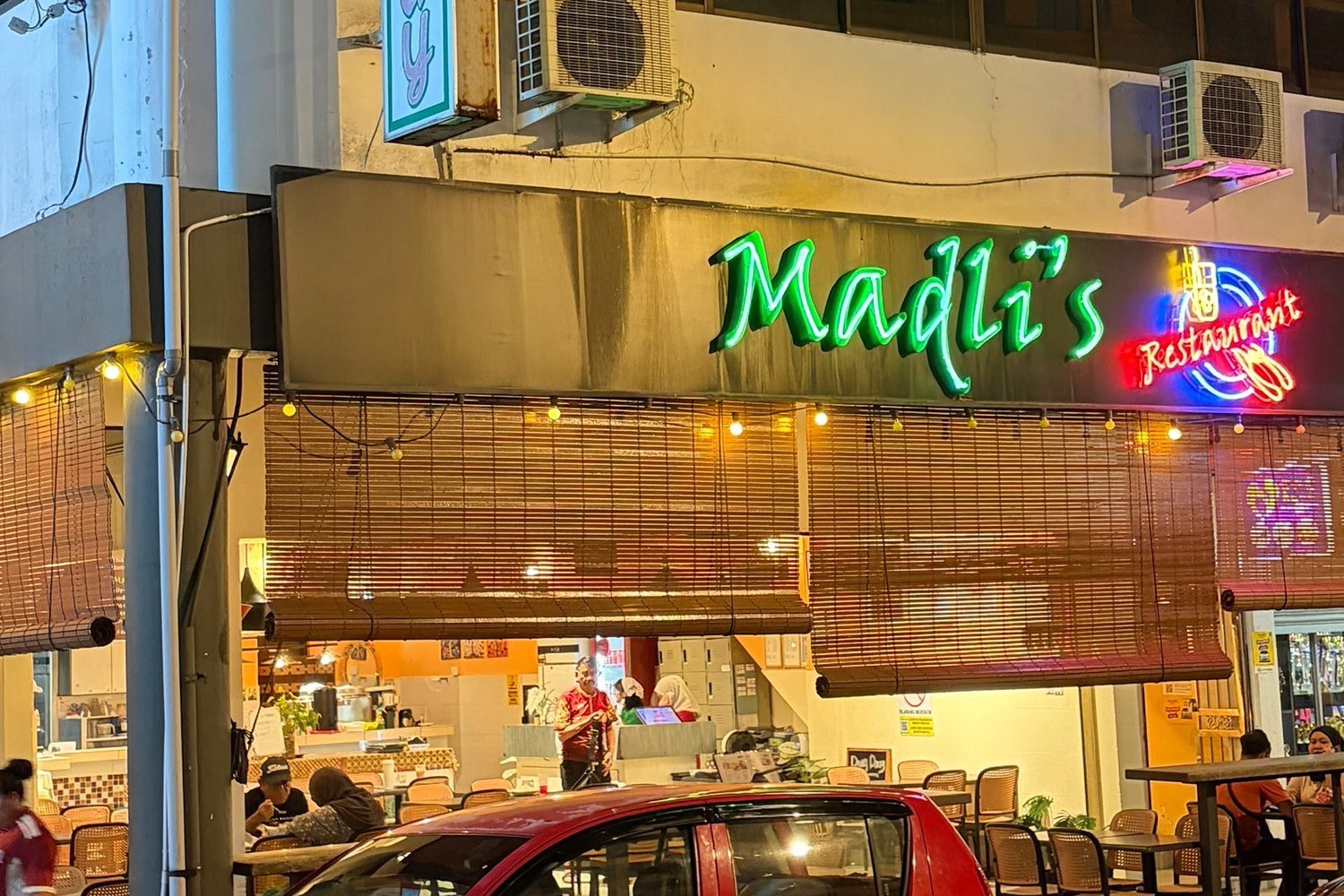 Madli's restaurant at night, neon sign glowing above the open dining front
